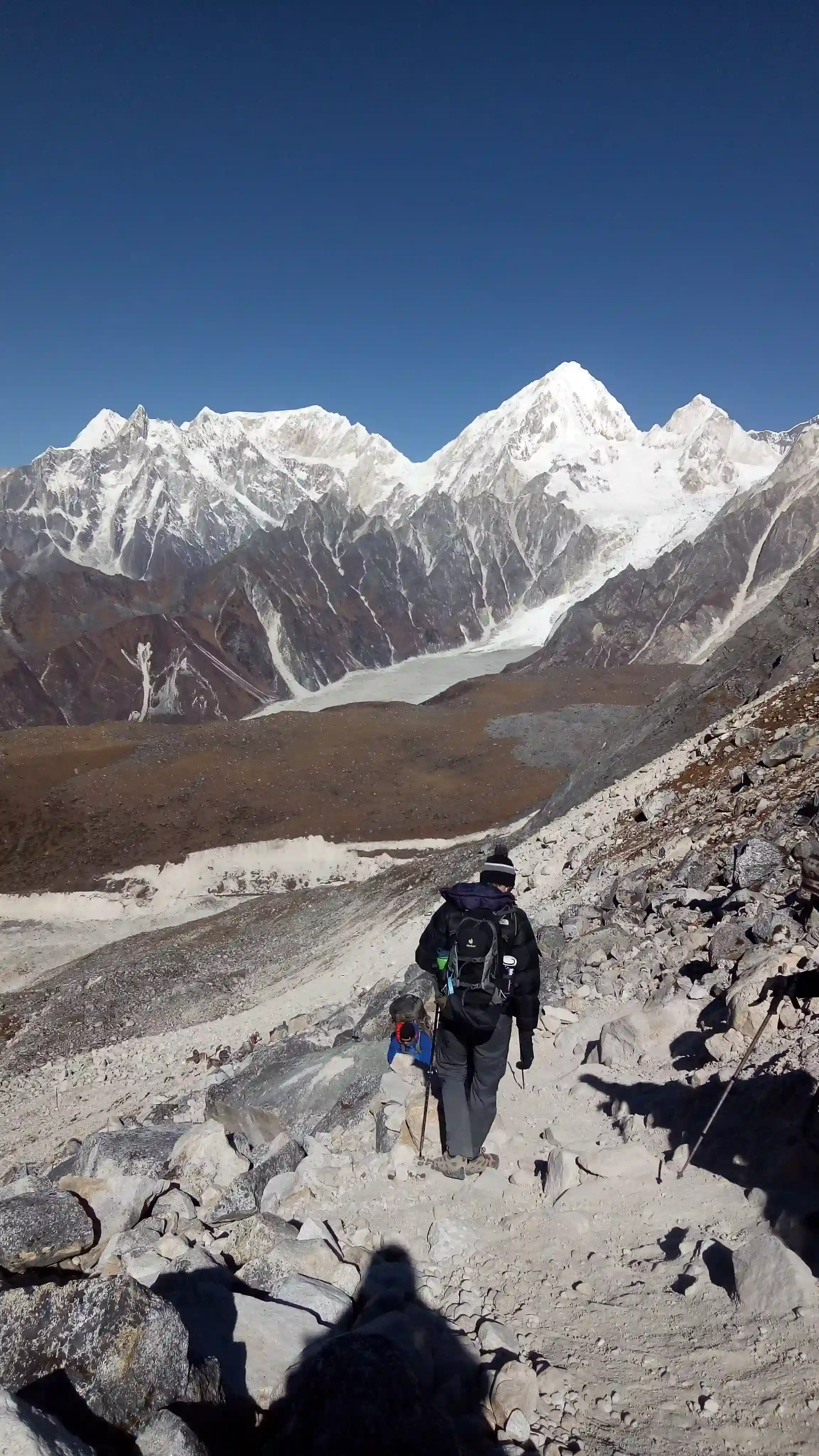 Trekker Crossing a Snowy Himalayan Mountain Trail
