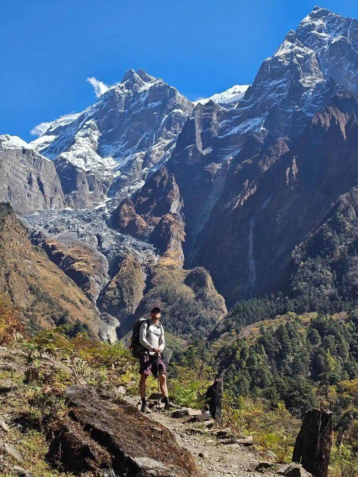 Trekker walking along a scenic mountain trail in the Manaslu region
